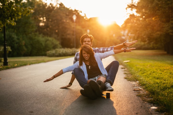 Couple riding skateboard at sunset